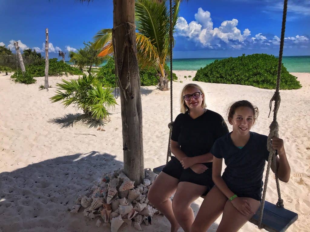 Girls on swing on beach at Cozumel Pearl Farm