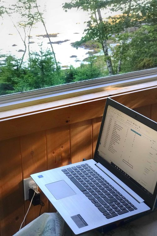 laptop in workspace facing Maine Coast